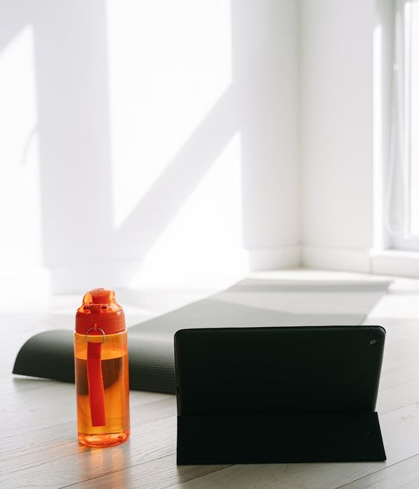 A calm setup for yoga with a mat, water bottle, and soft lighting.